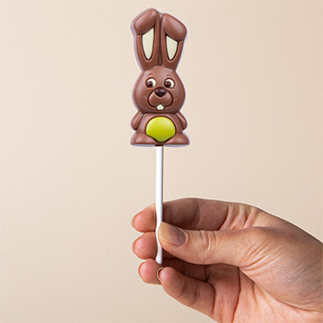 Grüner Schokoladenhase zu Ostern, in der Hand präsentiert