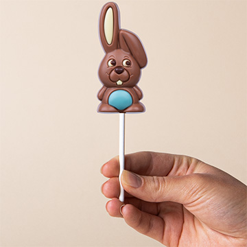 Blauer Schokoladenhase zu Ostern, in der Hand präsentiert