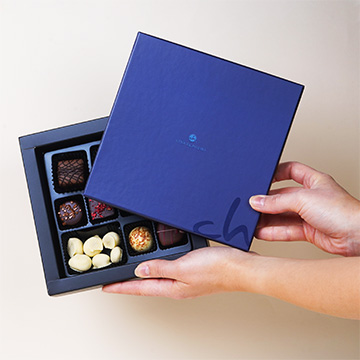 Set von Schokoladenpralinen Momente mini in den H&auml;nden pr&auml;sentiert