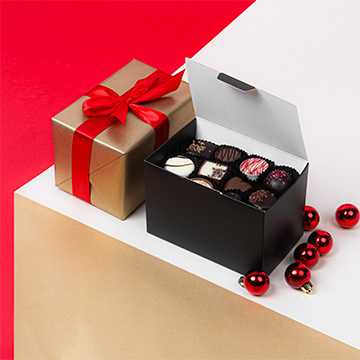 Ballotin Supreme gefüllt mit belgischen Schokoladenpralinen in einem weihnachtlichen Arrangement