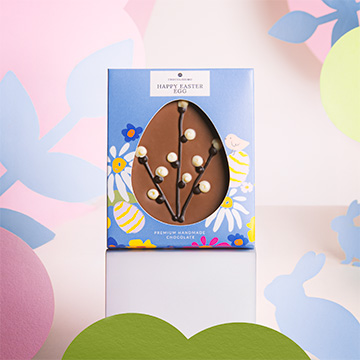 Flaches Schokoladenei mit Weidenkätzchen zu Ostern