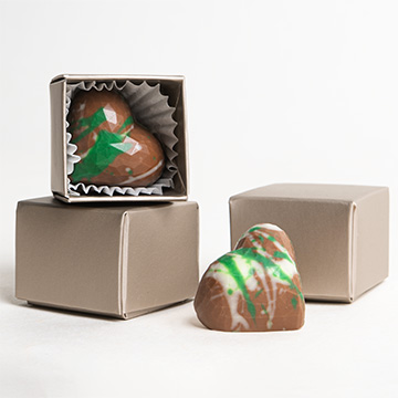 Herzförmige Pralinen in einer dekorativen grauen Schachtel