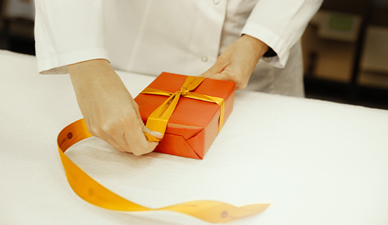 dekoratives goldenes Päckchen mit Pralinen für Weihnachten