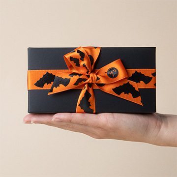 Drei Schokoladen-Halloween-Totenköpfe auf einer Hand