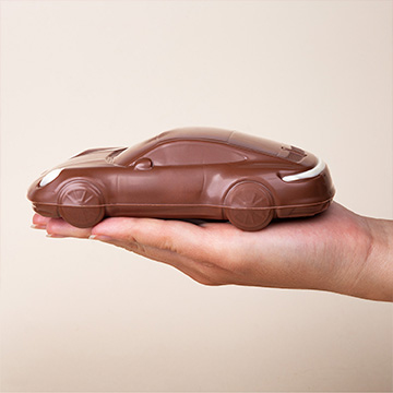Schokoladen-Porsche Carrera auf der Hand präsentiert